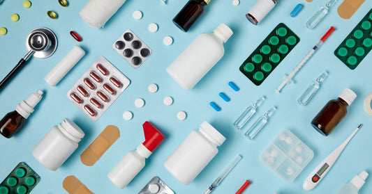 A a blue table, with a variety of different medical supplies next to pills, needles, and bandages.